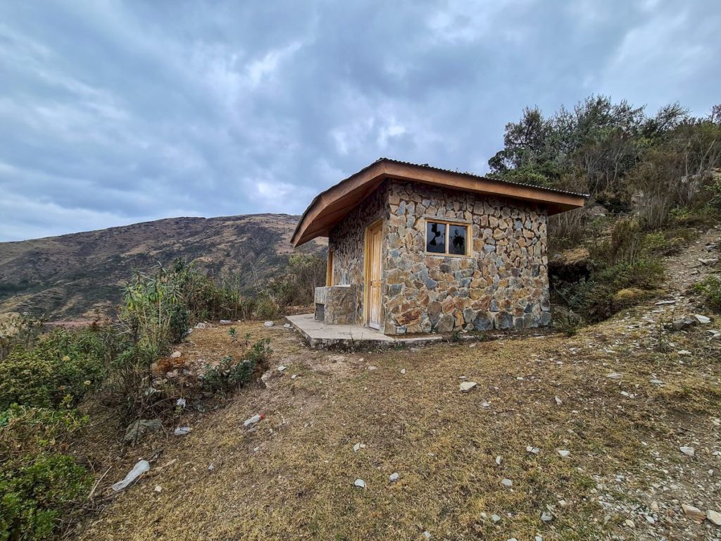 Opuszczone schronisko oraz toaleta spotkane na trasie trekkingu Salkantay. Wybita szyba w budynku