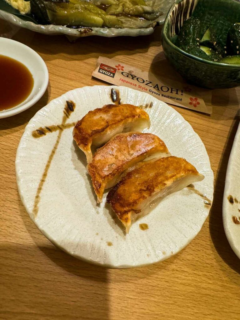 Smażone pierożki gyoza w towarzystwie różnych przystawek.