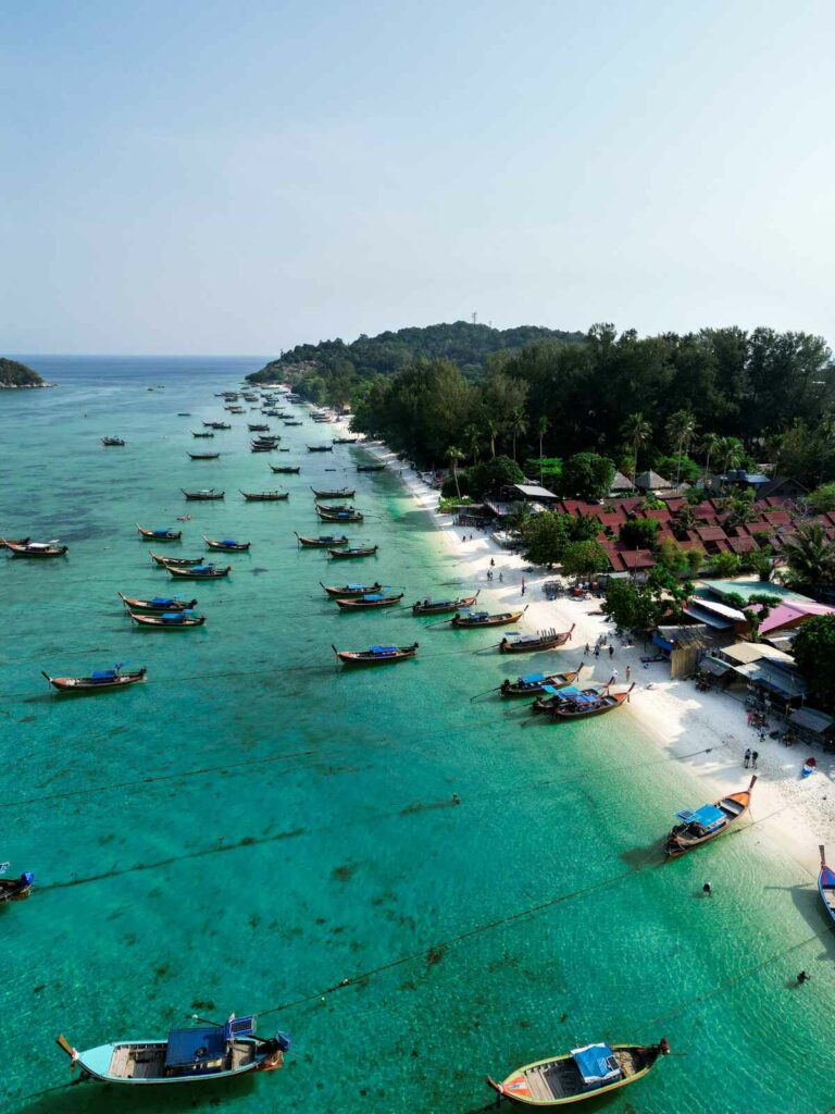 Piękna plaża na wyspie Koh Lipe z tajskimi łodziami, widok z drona.