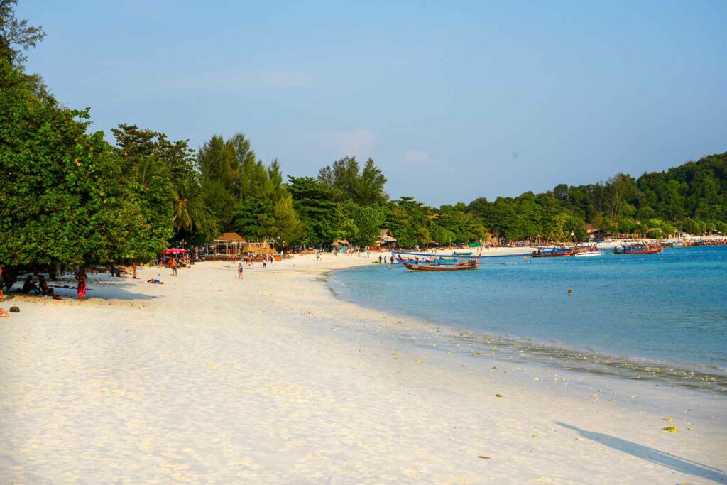 Długa, piaszczysta plaża podczas zachodu słońca.