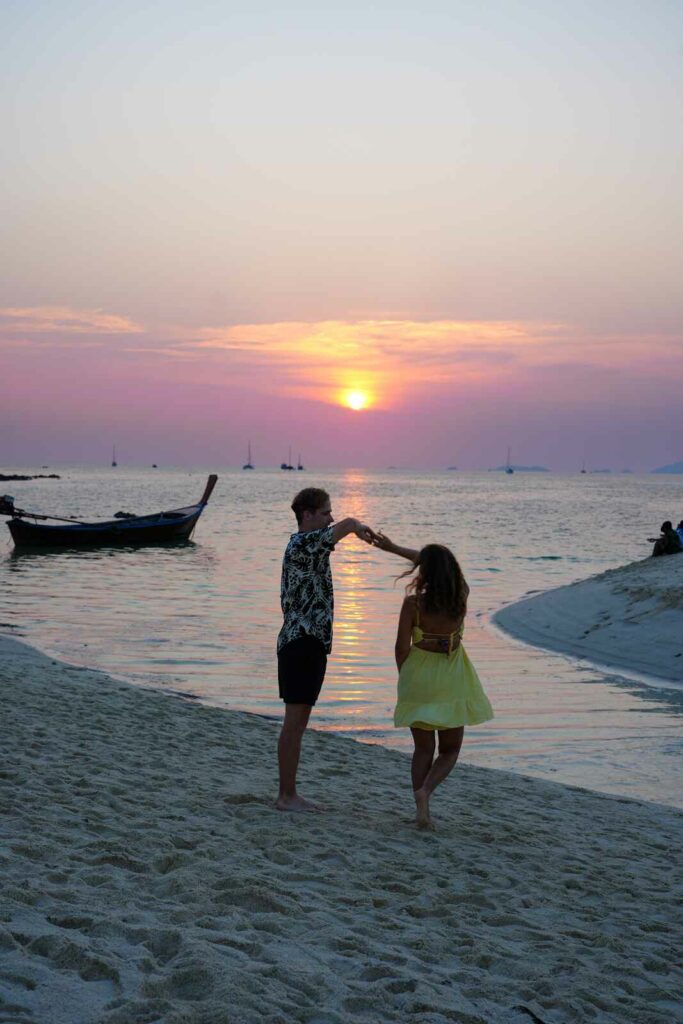 Młoda para tańcząca przy zachodzie słońca na plaży, na wyspie Koh Lipe.