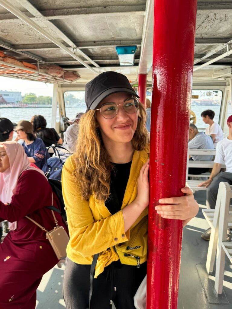 Dziewczyna trzymająca się poręczy na statku podczas rejsu po Chao Phraya River w Bangkoku.