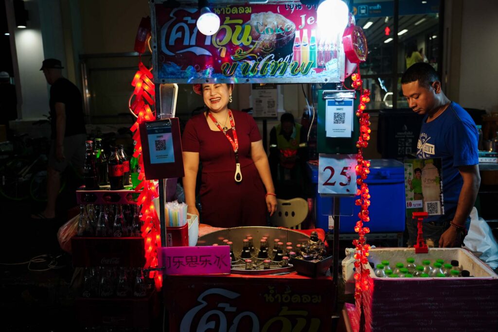 Uśmiechająca się sprzedawczyni viralowego napoju — coke jelly. Chinatown w Bangkoku.
