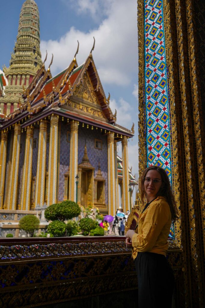 Dziewczyna spoglądająca przez balkon w The Temple of the Emerald Buddha w Bangkoku.