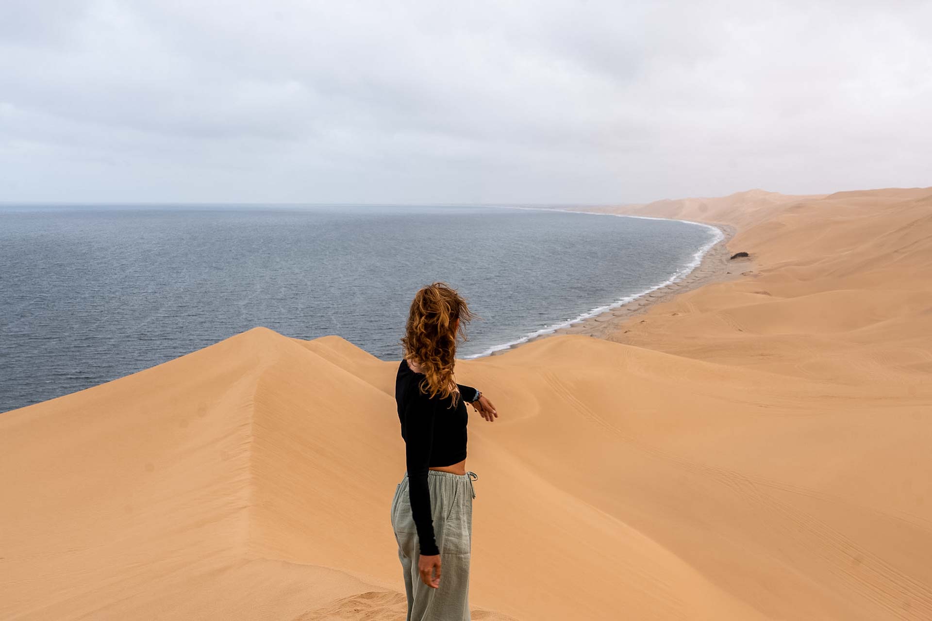 Dziewczyna pozująca na tle pustyni i oceanu - Sandwich Harbour.