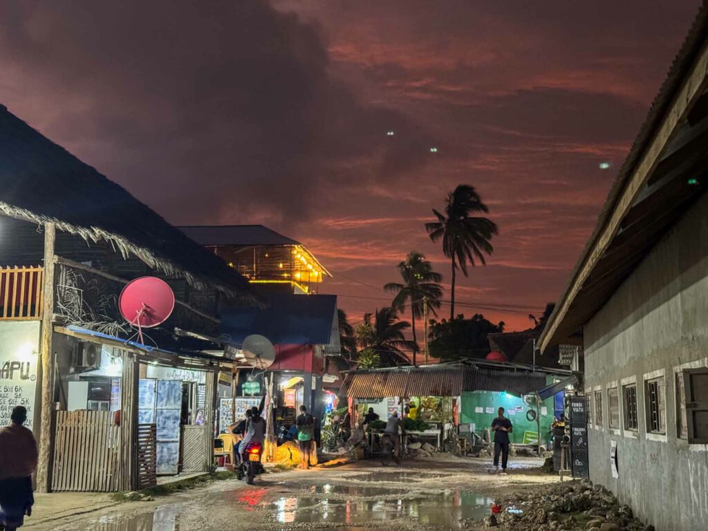 Zachód słońca widziany z uliczki w Paje na Zanzibarze w Tanzanii.
